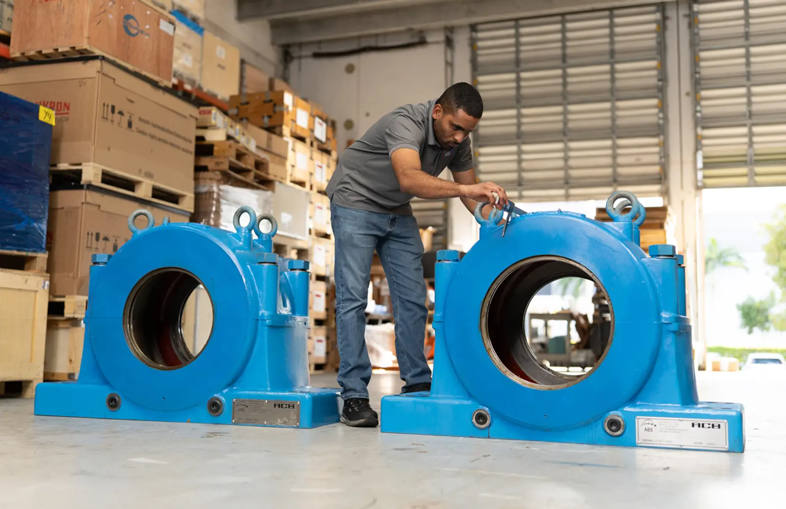 Engineer inspecting heavy-duty ACB bearing housings for driven shaft pinion support in industrial drive applications