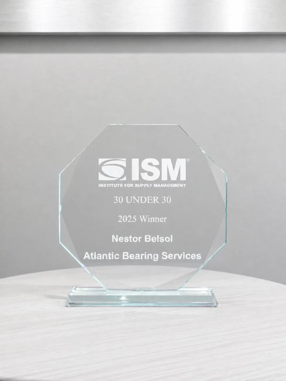 Glass award from ISM recognizing Nestor Belsol of Atlantic Bearing Services as a 2025 30 Under 30 winner