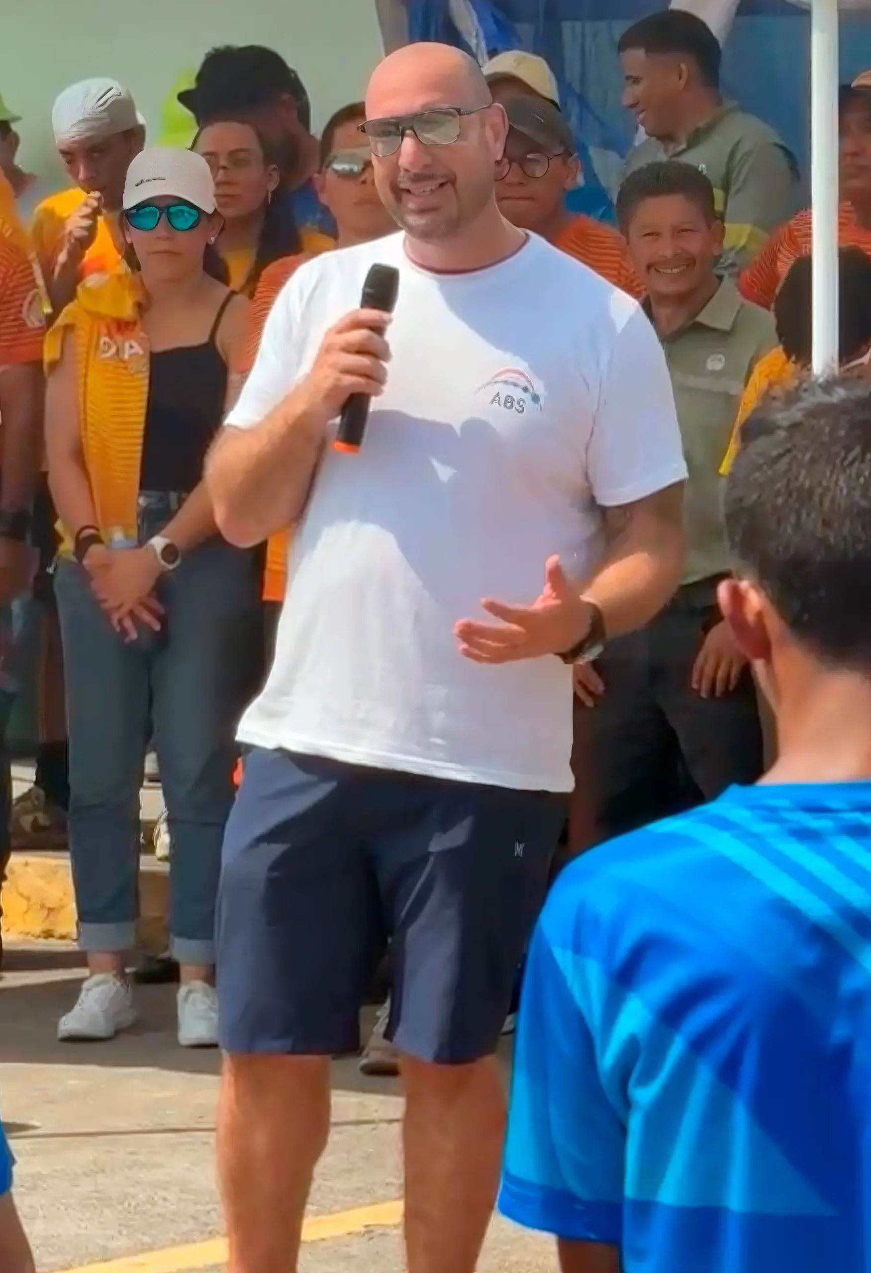 Jose Ugalde wearing an ABS shirt and speaking into a microphone at Santa Ana’s 2026 sporting event in Guatemala.