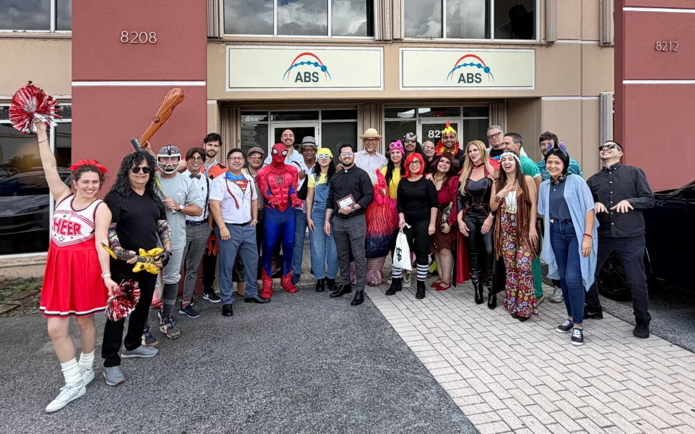 Group of Atlantic Bearing Services employees wearing creative Halloween costumes and posing for a photo outside the ABS Miami office during the 2026 Halloween celebration.