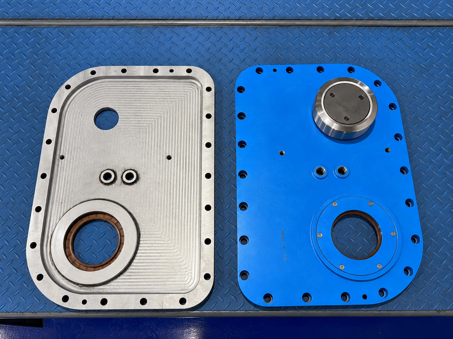 Redesigned gearbox cover components for a steel industry application, showing the machined interior and blue exterior with improved seal accessibility.